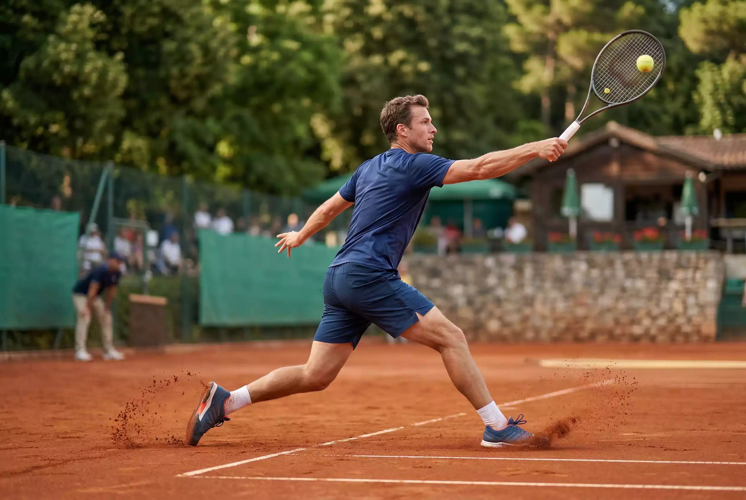 Tennis Belaganalyse – Sandplatz-Szene mit Spieler beim Grundlinienschlag und typischem Ziegelmehl